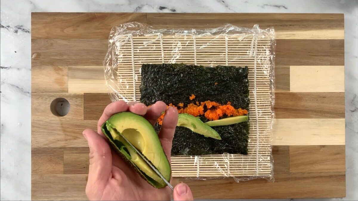 Cut the avocado to be added to the salmon skin roll.