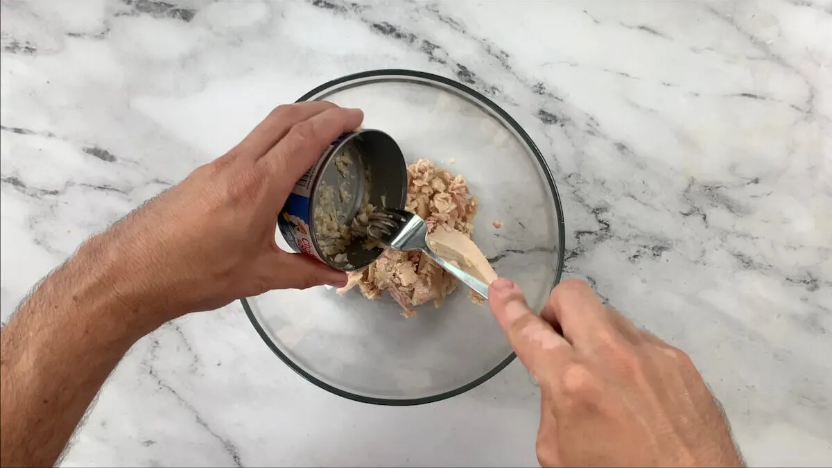 Add four cans of drained tuna into a large mixing bowl