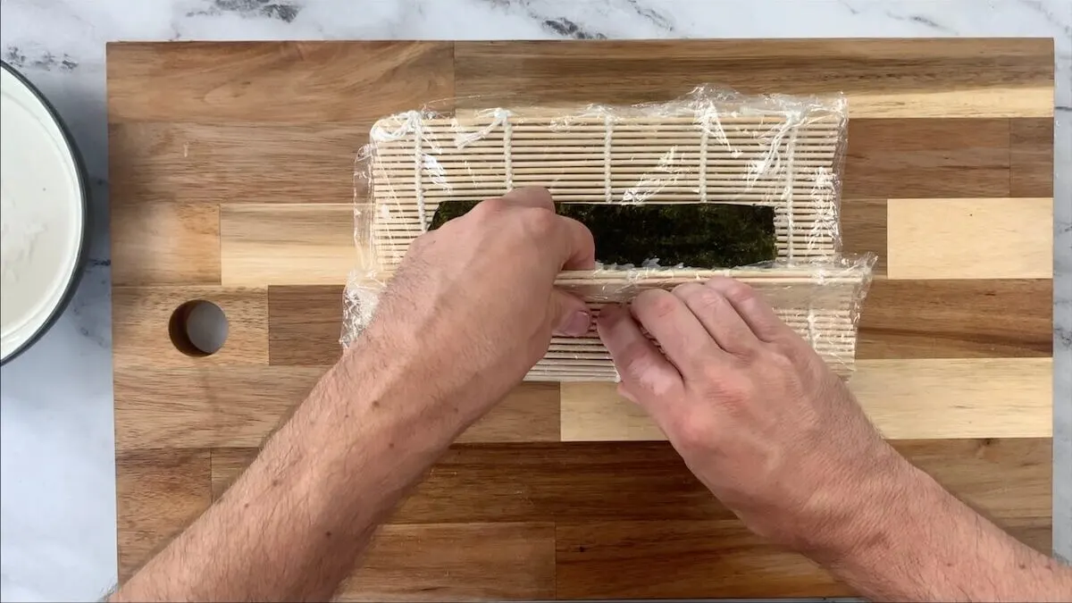 Roll the sweet potato roll using the sushi mat as your guide.