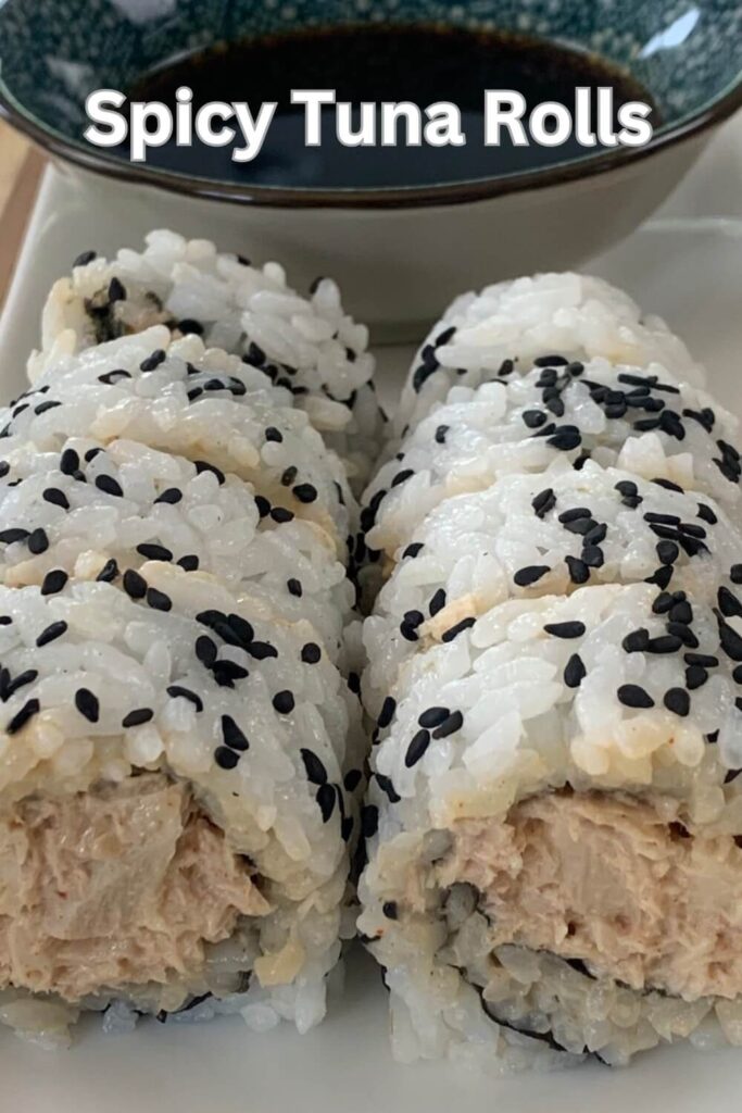 Spicy Tuna rolls arranged on a white sushi platter with a ramekin of soy sauce in the background.