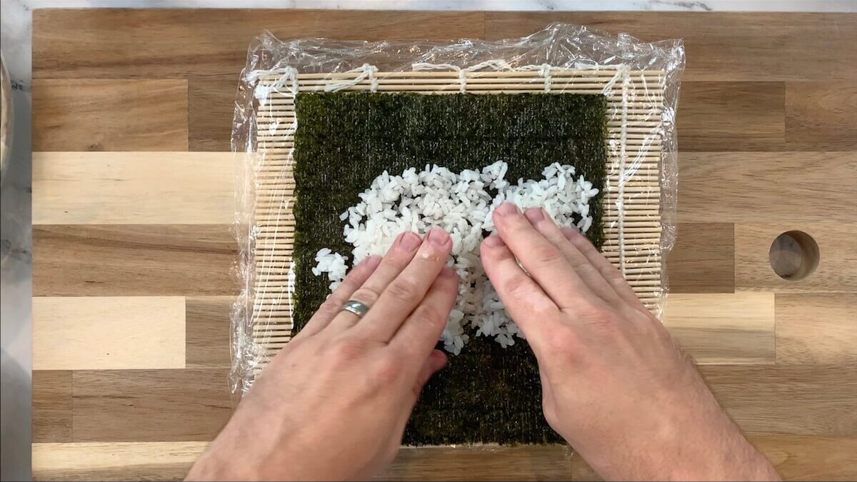 Spread rice onto the nori sheet that you plan on using for the chicken teriyaki roll.