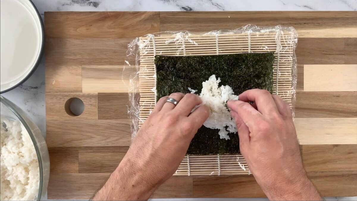 Spread sushi rice onto the nori sheet for your spicy tuna roll.