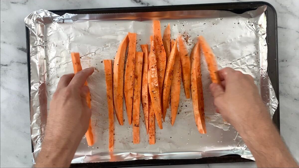 Toss the sweet potatoes to ensure the oil and seasonings are evenly spread over the potatoes.