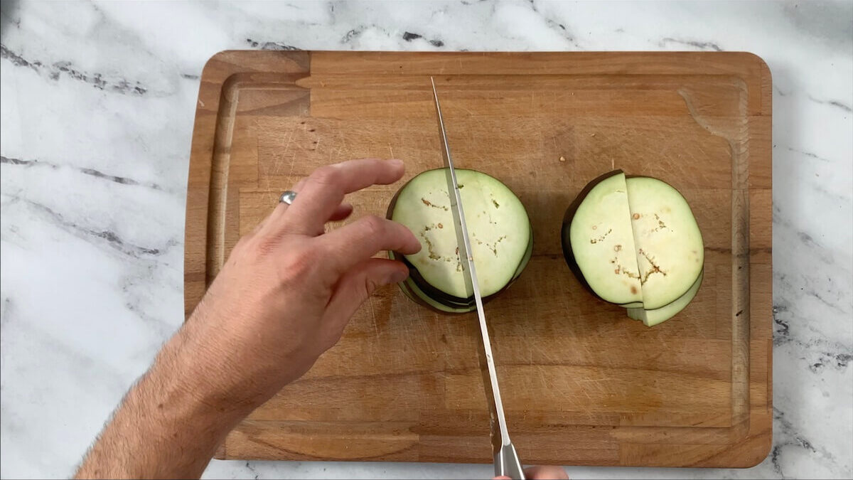 Cut the eggplant into slices.  After that, cut the slices in half so they will better fit into the vegetable tempura roll.