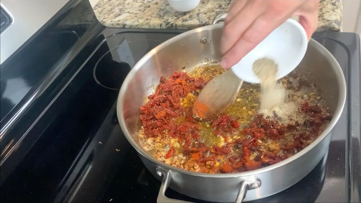 After the garlic is cooked, add sun dried tomatoes, paprika, and Italian spices.  Mix together until combined.