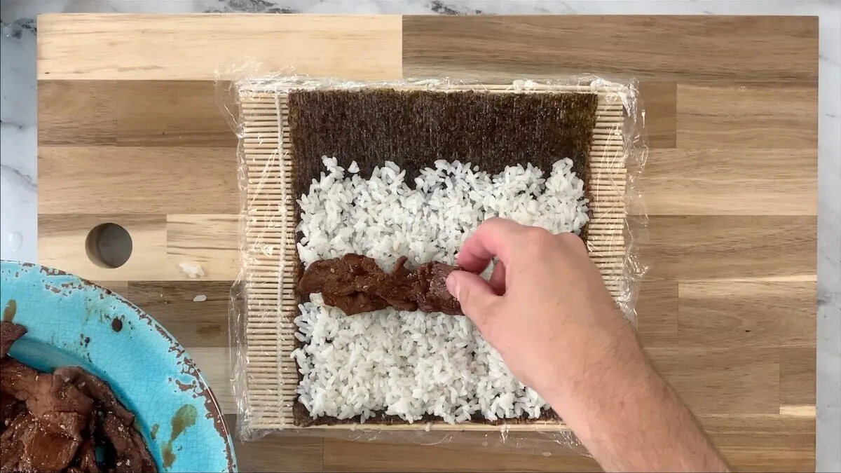 Add the yakiniku beef to the rice for the beef roll.