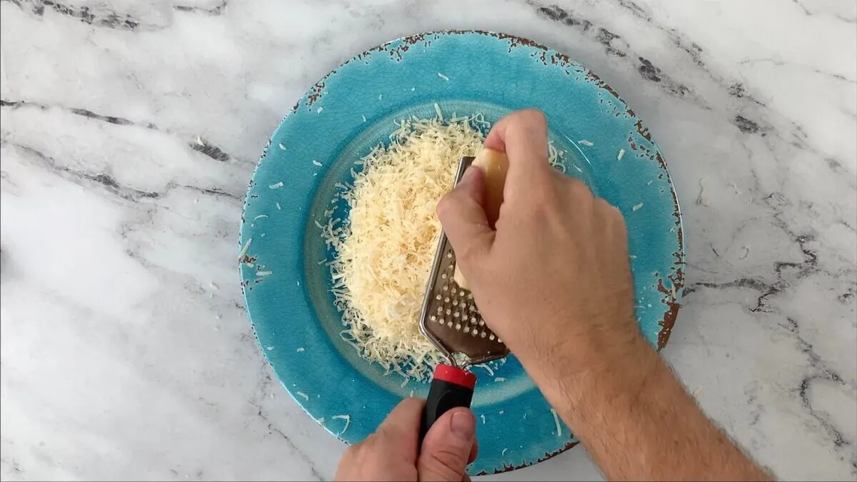 Grate parmesan cheese.