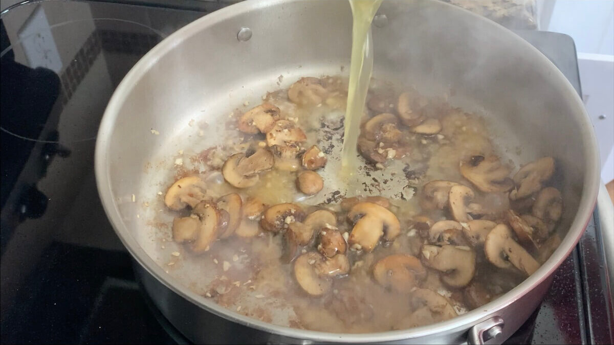 Add chicken broth to the pan and scrape bits from the bottom of the pan.  This helps to give the Boursin cheese pasta a greater depth of flavor.