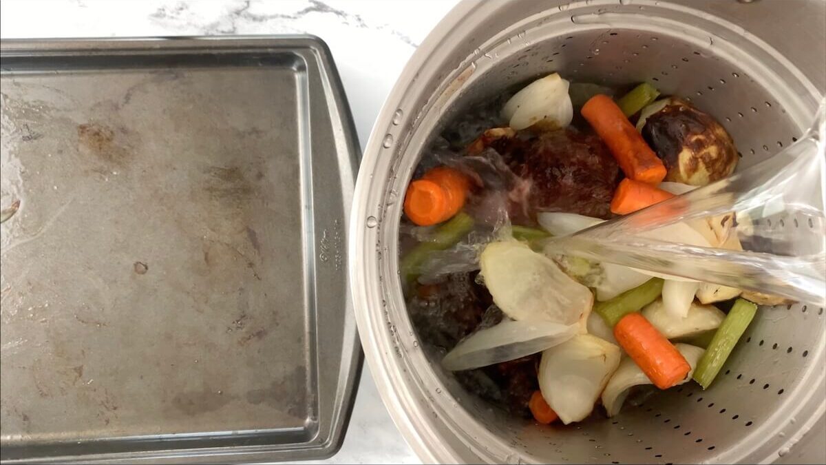 Add enough cold water to the pot to cover all the vegetables and soup bones.