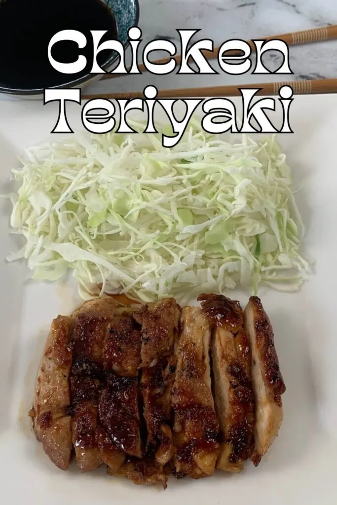 Chicken Teriyaki vertical pic served on a white plate with a ramekin of teriyaki sauce and a bed of Japanese coleslaw.