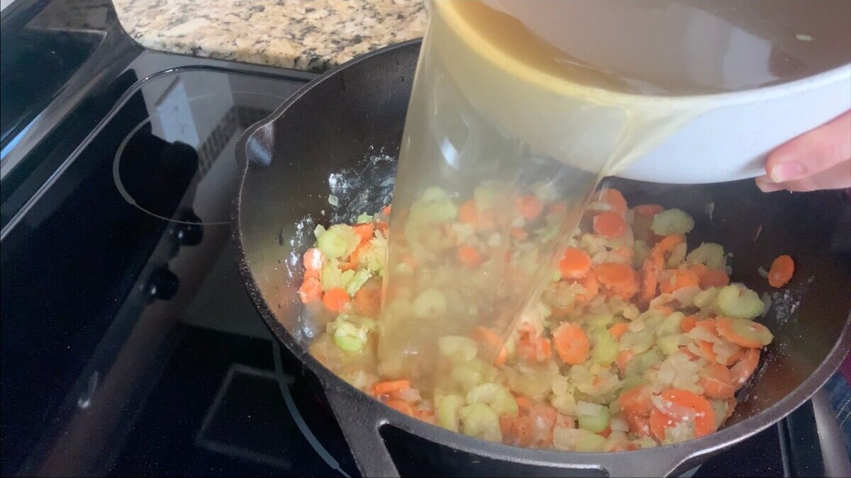 Add broth to the vegetables to make the base of the vegetable beef soup.