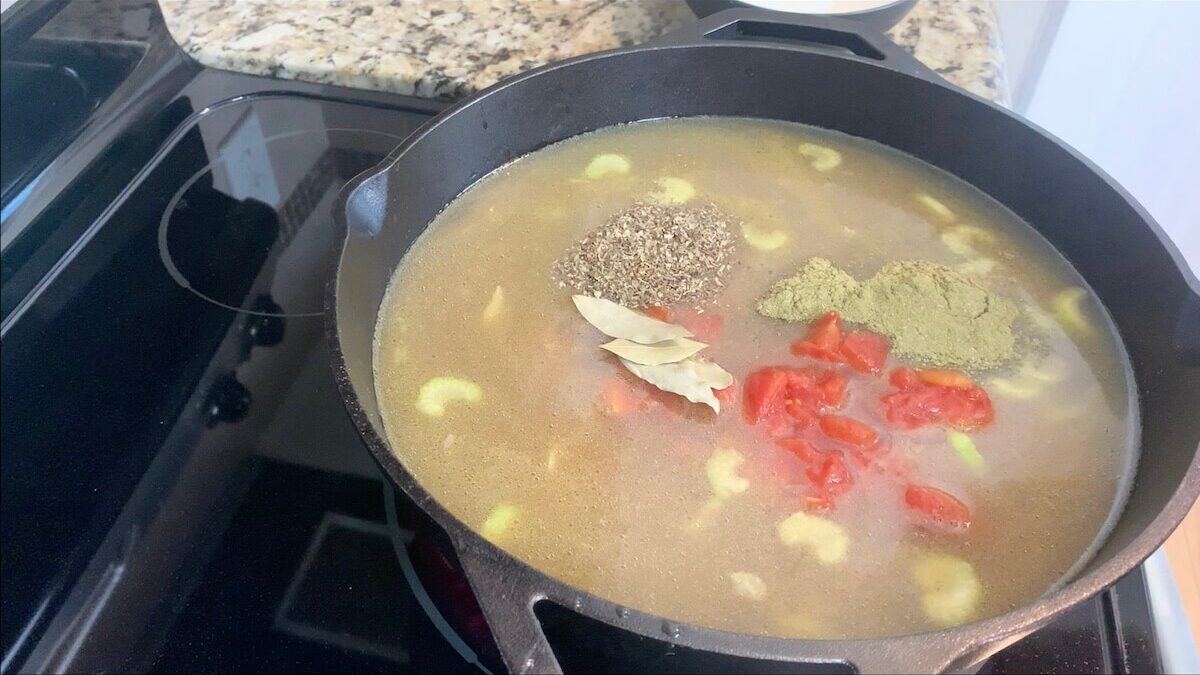 Add tomatoes and spices to the vegetable beef soup.